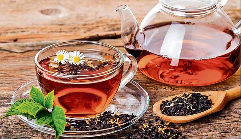 فنجان چای سیاه با برگ‌های تازه
